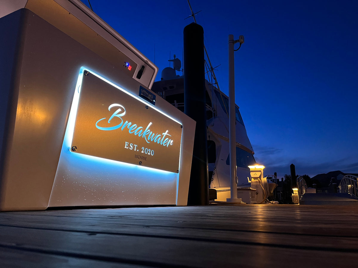 Custom illuminated MAZARINE dock box beside a yacht